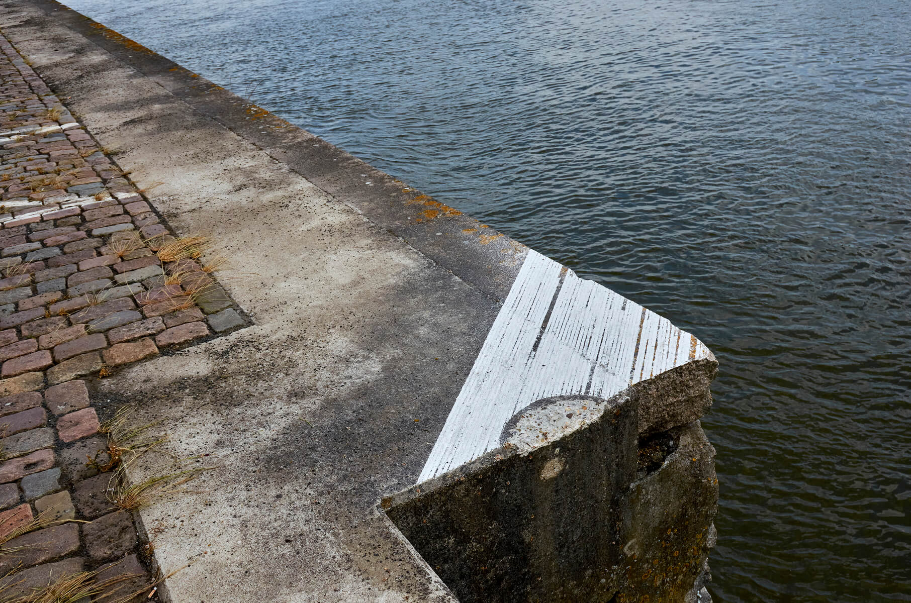 Chalk linedrawing on a the edge of a quay, just above the water